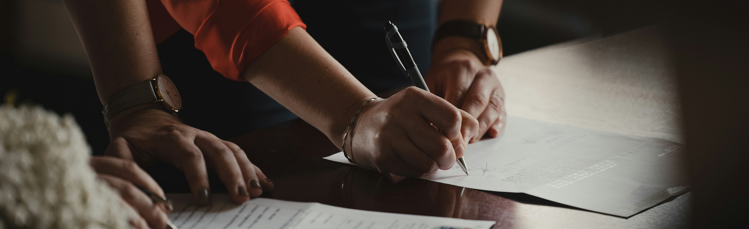 image of two people signing document